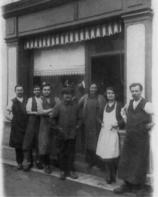 Groupe de personnes se tenant devant l'entrée d'un magasin.